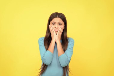 Olumsuz duygularını ifade et. Uzun saçlı mutsuz bir çocuk. Güzellik ve moda. Kadın manken. Genç bir kızın güzel görünüşü. Sarı arkaplanda çocuk portresi.