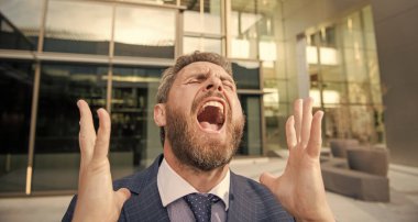 Resmi takım elbiseli, iflasın eşiğinde bağıran sakallı iş adamı..