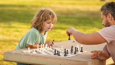 Stratejik ve taktiksel. Özel ders. Baba ve çocuk mantık oyunu oynuyorlar. Baba oğul dışarıda satranç oynuyor. Babalar günü. Mutlu bir aile. Ebeveynlik ve çocukluk. Şah mat. birlikte zaman geçirmek..