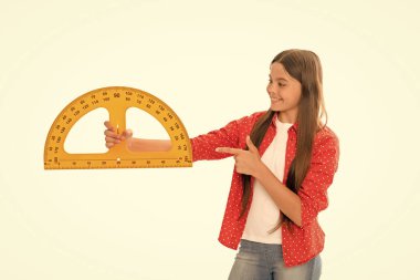 Boyutunu ölçün. Trigonometri kırtasiyesi. Ölçme ve ölçme. Çocuk eğitimi. Matematik. Gülümseyen genç kız işaret parmağıyla taşıyıcıyı işaret ediyor. Okula dönüyorum. Cebir ve geometri. çocuk matematik okuyor.