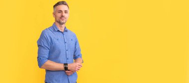 smiling adult man with graying hair on yellow background, fashion. Man face portrait, banner with copy space