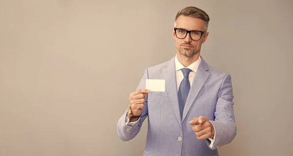 call me. identification. personal data document. handsome man with credit or debit card, copy space. businessman show business card pointing finger. grizzled business man demonstrating id.