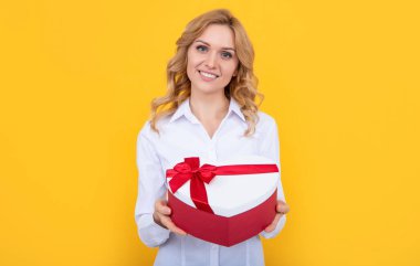 Mutlu kadın sarı arka planda mevcut kalp kutusunu tut..