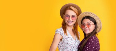 Mother and daughter kid banner, copy space, isolated background. smiling mother and child in straw hat on yellow background