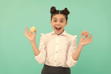 teen girl dental care. sweet tooth. yummy. patisserie biscuits. surprised child with dessert bakery. kid hold french macaron. macaroon cookie. confectionery. sweet french cakes.
