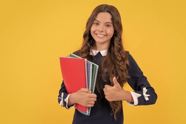 happy kid going to do homework. teenager student hold copybooks. education in high school. thumb up. schoolgirl with notebook. back to school. teen girl ready to study. happy childhood.