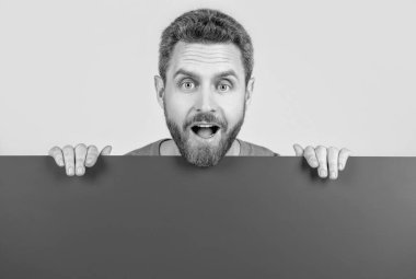 Reklam ve pazarlama için fotokopi alanı olan boş mavi pankartın arkasındaki olgun sakallı adam hayrete düştü..