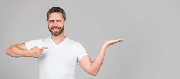 Happy Handsome Man Smile Pointing Finger Open Hand Grey Background — Stockfoto