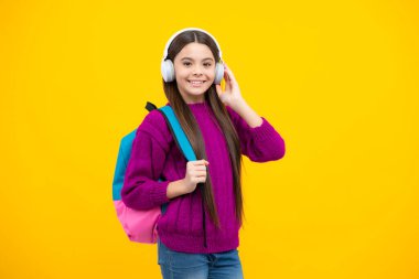 İzole edilmiş stüdyo geçmişi olan kulaklıklı bir kız öğrenci. Okul ve müzik konsepti