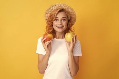 Hasır şapkalı neşeli kızıl kadın Elma tutuyor, yaz.