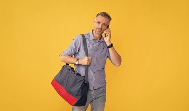 mobil teknoloji gibi ses teması. Cep telefonundan konuş. İletişim. Yetişkin iş adamı akıllı telefonuyla seyahat çantasıyla konuşur. Adamın sohbet çantası var. Telefon görüşmesi..