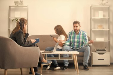 Çocuk ve babası sosyal hizmet görevlisiyle konuşuyor. Kişiler arası ilişkiler. Yaşam koçu. Telefon bağımlılığı. Baba ve çocuk psikolog seansında. Aile terapisi. Veli toplantısı. Ebeveynlik ve babalık.