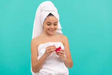 Çocuk yüz kremi kullanıyor. Gülümseyen kız saç maskesi tutuyor. Cilt kremi olan çocuk. Günlük alışkanlık ve kişisel bakım. Cilt güzelliği. Güzellik kozmetiği. Temizleme fırçası. Gençler için kozmetik ürün sunumu.