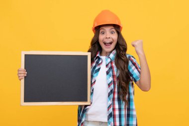 childhood education. copy space for announcement. happy workers day. happy teen girl laborer hold blackboard. child advertising labor day. back to school. kid presenting novelty information.