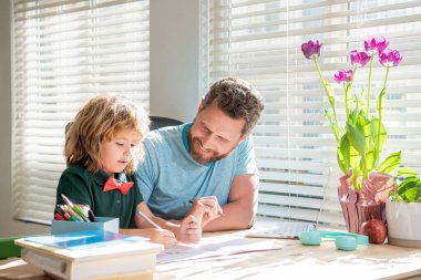 Mutlu sakallı baba, oğluyla okul ödevi yazıyor sınıfta, evde eğitim görüyor..
