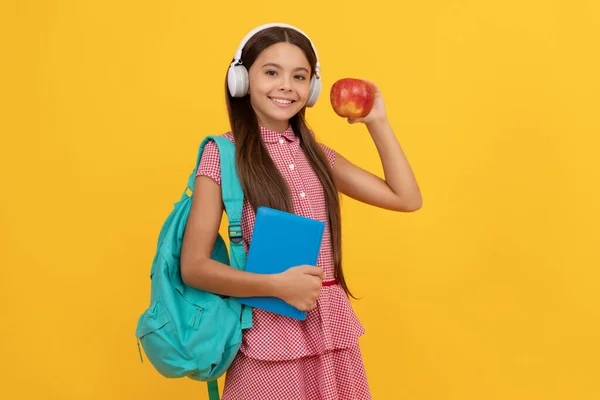 back to school. knowledge day. concept of education. kid in headphones with workbook and apple for lunch. september 1. healthy childhood. child with school bag. music. happy teen girl carry backpack.