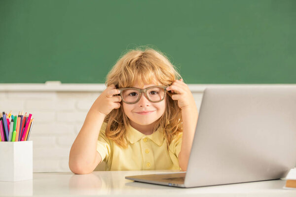september 1. e-learning. child studying on computer. happy teen boy in classroom. back to school. knowledge day. concept of online education. nerd kid in glasses with laptop.