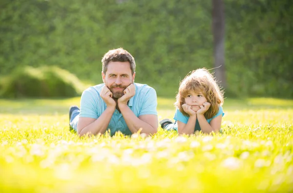 happy family of daddy and son child relax in summer park green grass, fatherhood.