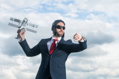 Takım elbiseli iş adamı ve pilot şapkalı uçak oyuncağı. kontrol zamanı.