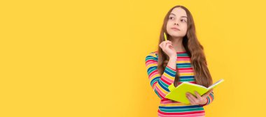 Düşünceli bir çocuk, elinde kalem ve defter sarı arka plan olan okul kompozisyonu üzerine düşünüyor. Liseli kız öğrenci pankartı. Kopya alanı olan öğrenci portresi