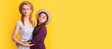 Mother and daughter kid banner, copy space, isolated background. positive mom and daughter in straw hat on yellow background