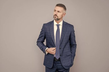 Girişimci ya da yönetici. Erkek resmi moda. Profesyonel traşsız CEO. Kol saati olan olgun bir patron. Formalite icabı kendine güvenen iş adamı. İş başarısı. Takım elbiseli, kır saçlı bir adam..