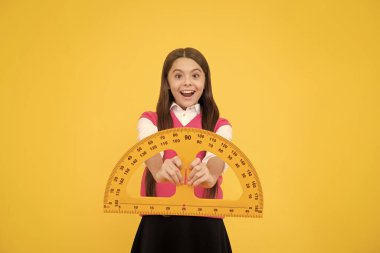 Hayretler içindeki çocuk okulda geometri okuyor. Cetvel ve kök disiplinlerle..