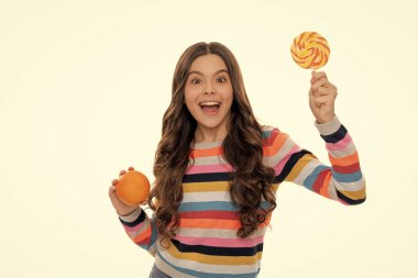 Süveterli, turuncu meyveli, lolipoplu, beyaz tenli, öğle yemeği yiyen bir çocuk..