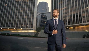 charismatic businessperson in businesslike suit outside the office, copy space, success.