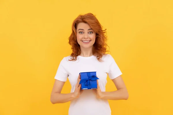 happy woman with present box on yellow background, shopping.