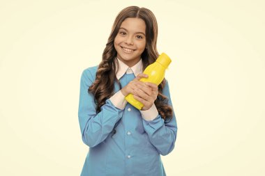 Mutlu çocuk kahvaltıda yanında vejetaryen sıvı yiyecek içeren sarı plastik şişeyi beyaz meyve suyu ile izole eder..