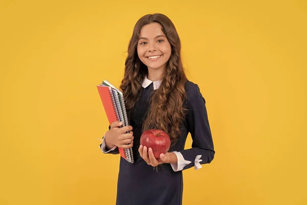 education in high school. schoolgirl with apple lunch. back to school. teen girl eat apple after study. healthy childhood. smiling kid going to do homework. teenager student hold copybooks.