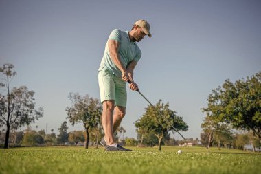 yeşil çimenli profesyonel golf sahasında aktif erkek golfçü..