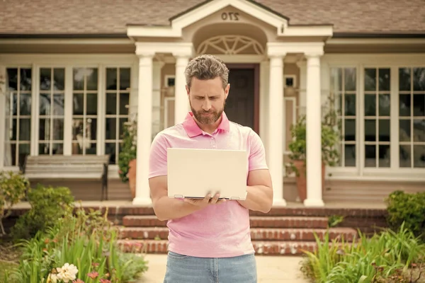 busy bearded man real estate agent selling or renting house online on computer, broker.
