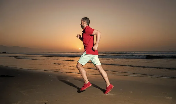 morning workout activity. healthy man running on sunrise beach. energetic summer. runner feel freedom. hurry up. endurance and stamina. sporty sprinter. sport athlete run fast to win in sea sunset.