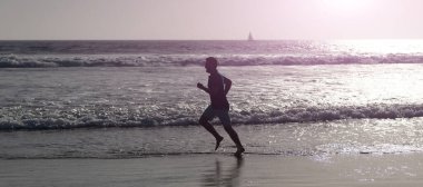 Koşan ve zıplayan adam, fotokopi alanı olan pankart. Sahilde koşan sağlıklı bir adam. Enerjik bir yaz. Koşucu özgürlüğü hisseder. Acele et.