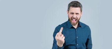 İnsan yüzü portresi, fotokopi alanı olan pankart. Kızgın adam yüksek sesle bağırıyor. Orta parmak, tek el hareketi, gri arka plan, suç.