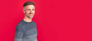 İnsan yüzü portresi, fotokopi alanı olan pankart. Neşeli yakışıklı adam kırmızı arka planda süveter giyiyor, yaşam tarzı.