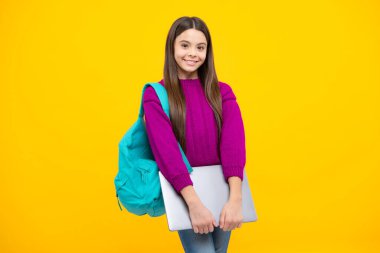 Teen schoolgirl hold laptop on isolated studio background. Cchool student learning online, webinar, video lesson, distance education