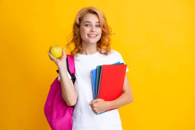 Sırt çantasındaki gülümseyen genç kız öğrencinin portresi. Not defterleri. Lise üniversitesinde eğitim