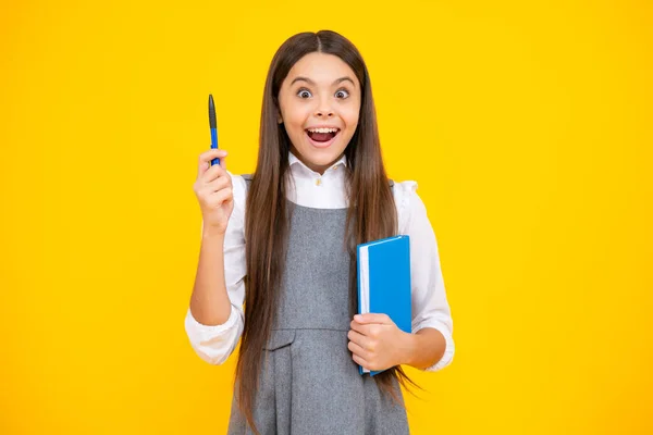 Excited face. Teen girl pupil hold books, notebooks, isolated on yellow background, copy space. Back to school, teenage lifestyle, education and knowledge. Amazed expression, cheerful and glad