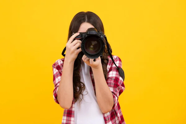 Teenager girl photographer with a dslr camera. Kid use digital camera. Child photographing. School of photography. Kid photographer beginner