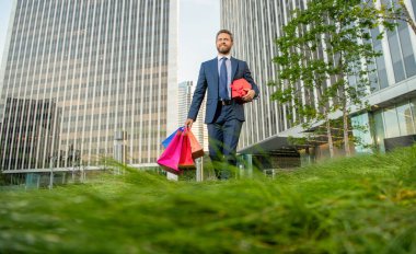 Sevgilim olur musun? Boks günü. Hediyeli kutusu olan yakışıklı bir adam. Erkek doğum günü hediyesi taşır. Adam alışveriş torbalarını tutuyor. Erkekler günü. Paketleri olan mutlu bir iş adamı. Satış ve indirim. Ona sürpriz yap..