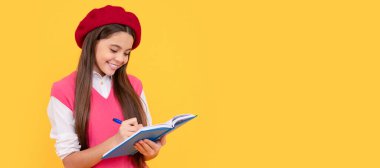Fransız bereli mutlu liseli kız not defteri ya da not defterine not alıyor. Öğrenci portresi, stüdyo afişi. Okul çocuğu yüzü, boşluklar