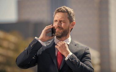 İletişim. İş adamı akıllı telefonda konuşur. Patron adam konuşuyor. İş görüşmesi. Ses bağlantısı. Telefon bağlantısı. Yetişkin CEO cep telefonundan konuşuyor. Telefon var. mobil teknoloji.