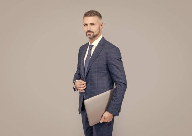 İnternette çalışan olgun bir iş adamı. İş başarısı. Programcı, bilgisayarı tut. Girişimci ya da yönetici. Çevik iş. Profesyonel ağ yöneticisi bilgisayarı tutuyor. Modern kablosuz bilgisayarı olan patron