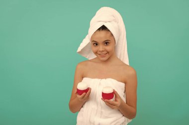 Cilt güzelliği. Güzellik kozmetiği. Temizleme fırçası. Gençler için kozmetik ürünler sunuyorum. Çocuk yüz kremi kullanıyor. Genç kız saç maskesi takıyor. Cilt kremi olan çocuk. Günlük alışkanlık ve kişisel bakım.