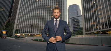 Erkek resmi moda. Kendine güvenen sakallı patron. Formalite içinde şık, olgun bir iş adamı. İş başarısı. Takım elbiseli başarılı bir adam. Yönetici yöneticisi ofis dışında.
