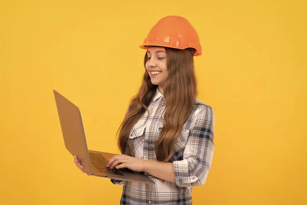 check the email. happy labour day. future career. teen girl in helmet use laptop. kid hold computer. building and construction. webinar. happy child worker wear hardhat. childhood online education.