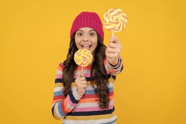 Lezzetli. Seçici odaklanma. Lolipop yalayan mutlu genç kız. Lolipop bayan. Renkli lolipop şekerli çubuklu hippi çocuk. Karamelli şeker dükkanı. Tatlı çocukluk hayatı. Diş bakımı. Tatlıya düşkünüm.
